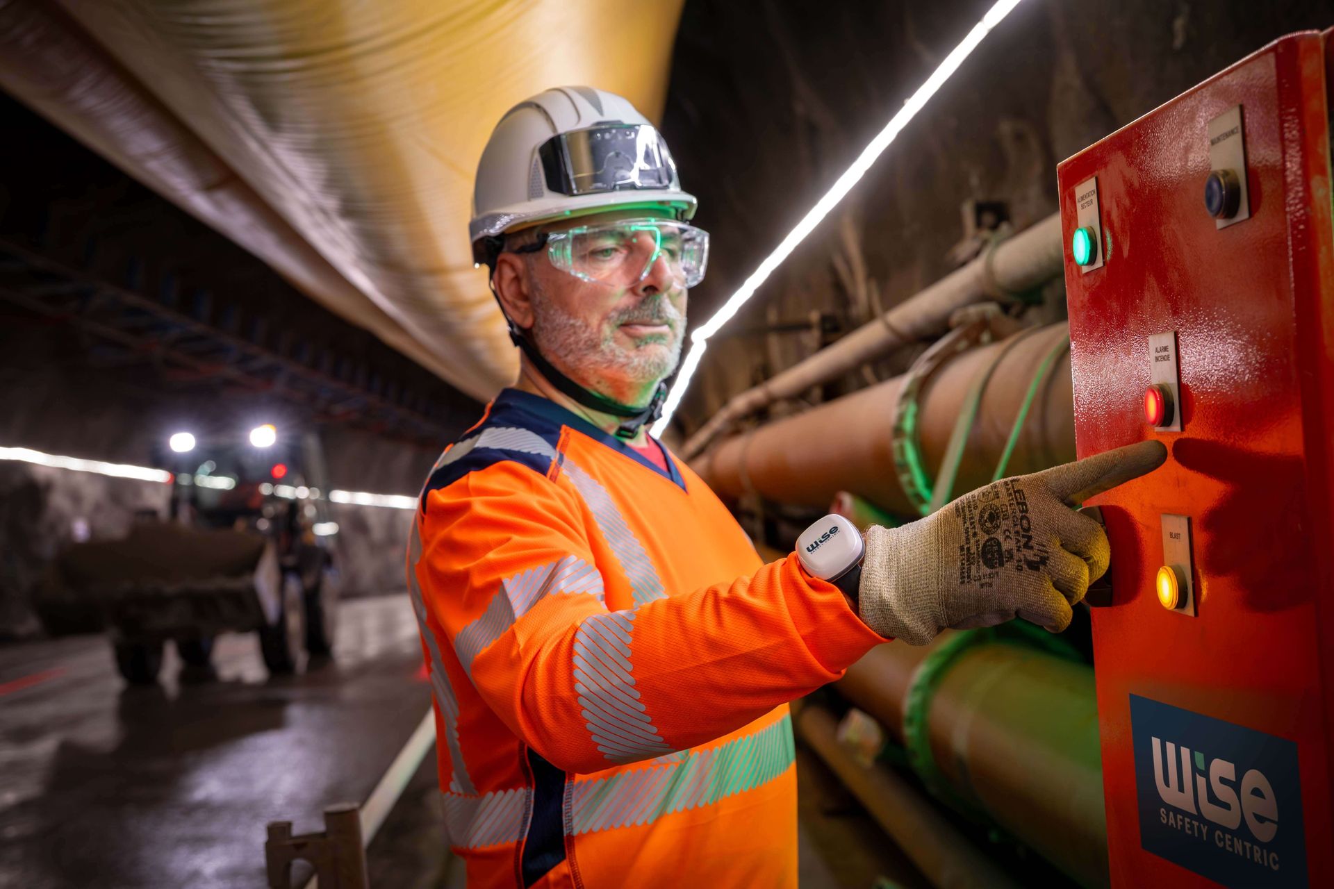 Worker using a WISE fire alarm unit in a tunnel under construction
